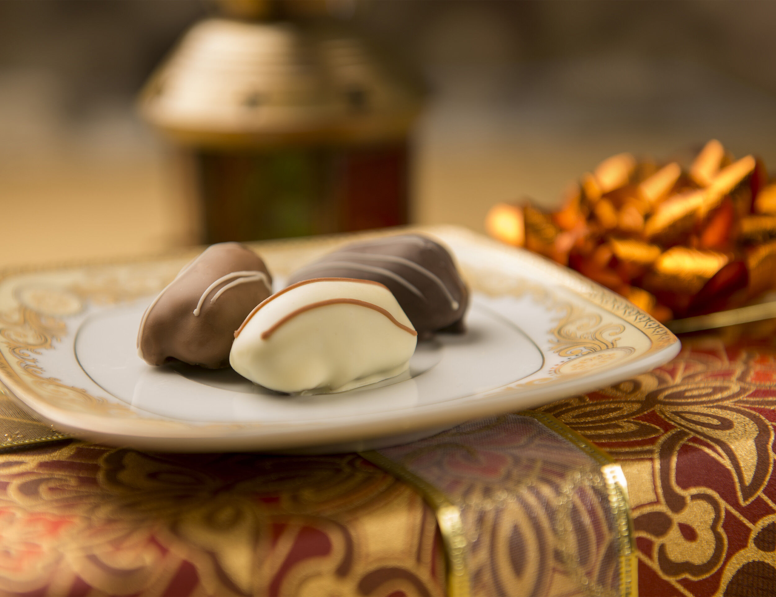Chocolate-covered dates elegantly arranged on a decorative plate, a popular Eid treat